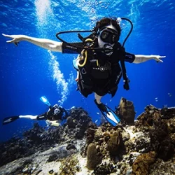 Scuba diver spreads her arms and glides through the water in Cozumel