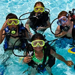 Four preteens scuba diving in a Playa Mujeres pool on PADI Bubblemaker program