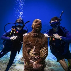 A father and his daughter remove their scuba regulators from their mouths during the PADI Scuba Diving Course in Cancun