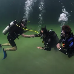 Two divers practice an scuba diving out-of-air exercise in Casa Cenote
